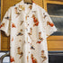 White shirt with vintage-style pin-up girl print on a hanger against a window background.
